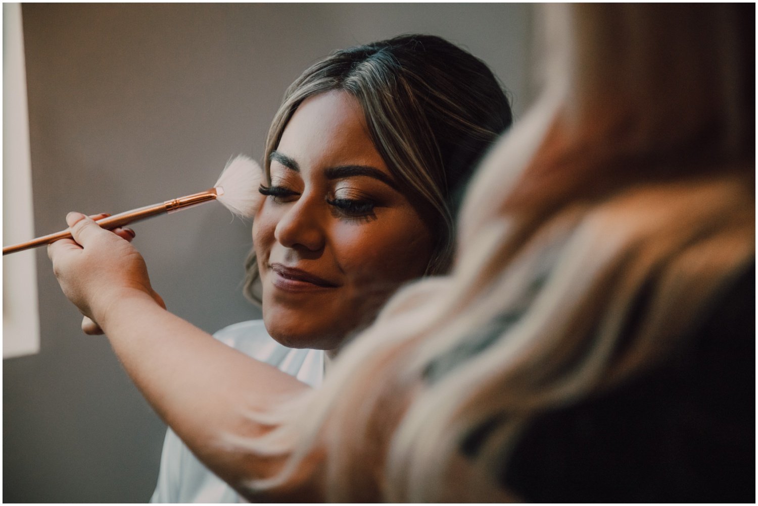 bride getting makeup done on wedding day