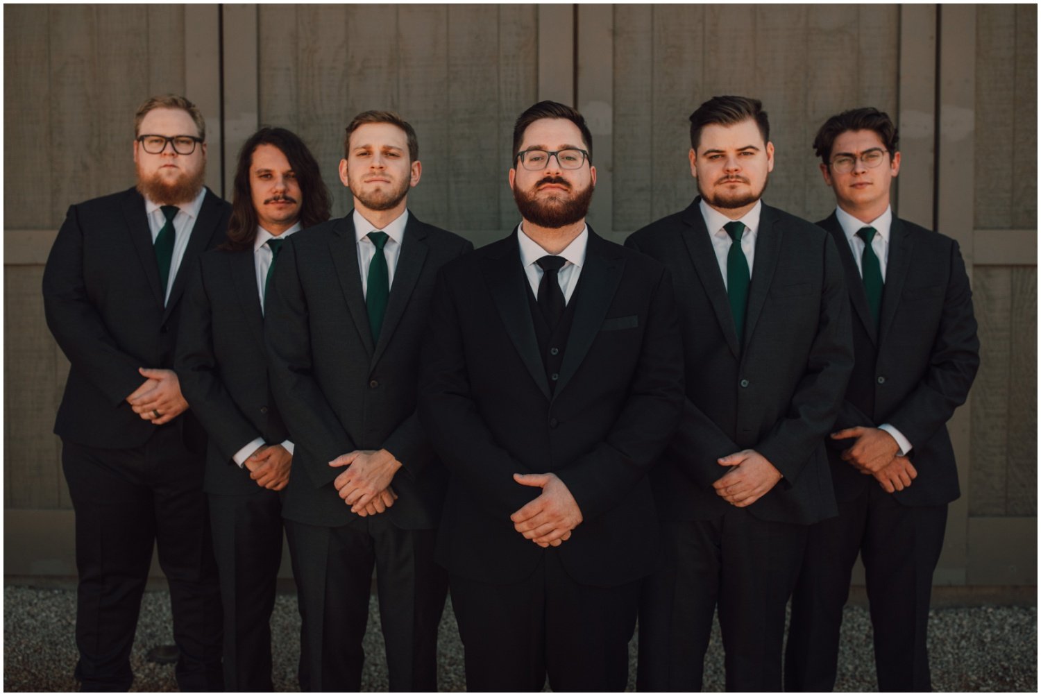 groomsmen wearing black suits and emerald green ties
