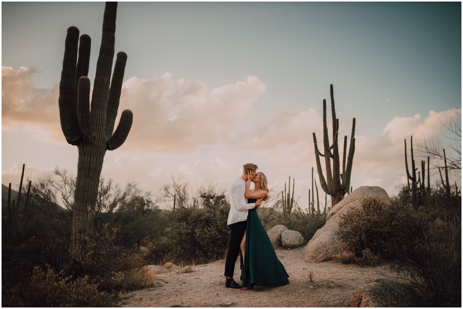 engaged couple engagement session portraits in the desert with long emerald green dress