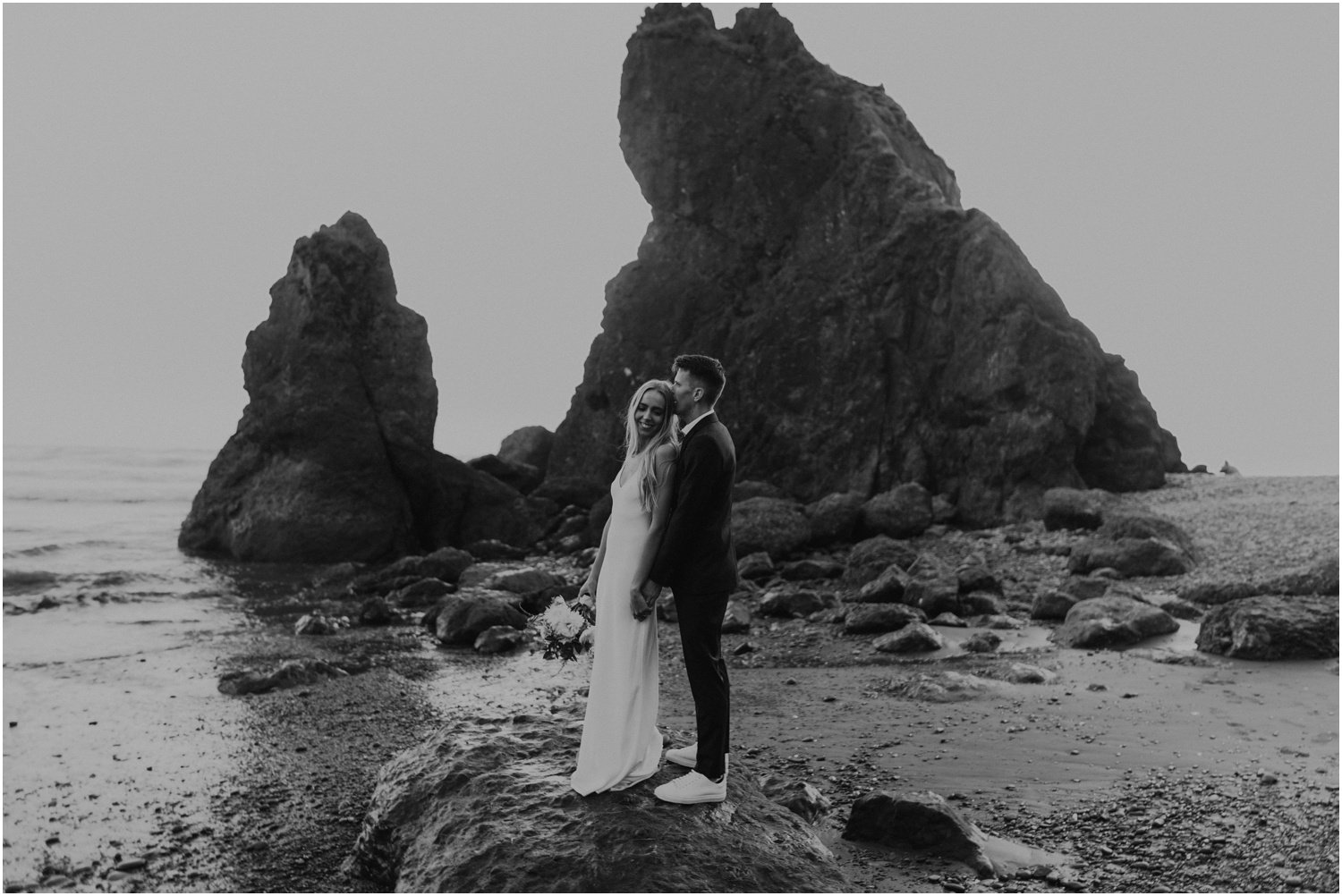 black and white photo of married couple taking portraits for their washington coast bridal session