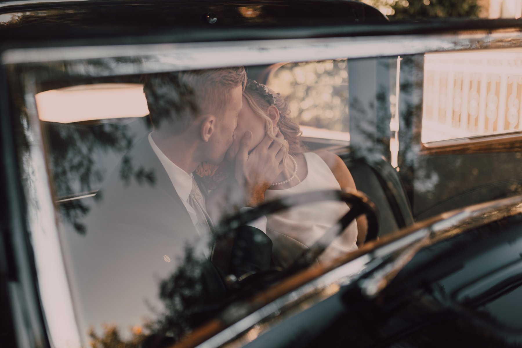 bride and groom posing with a vintage rolls royce for their paradise valley wedding in arizona