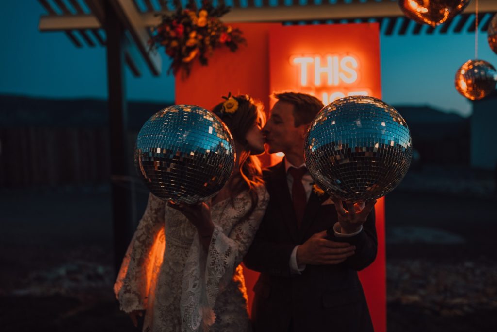 70s inspired wedding reception with disco balls and colorful florals