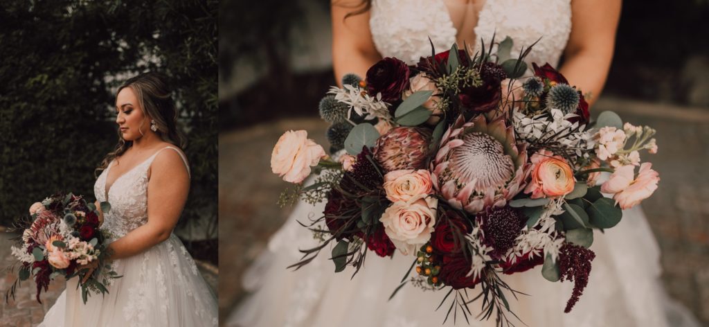 bride holding burgundy, blush, and peach bouquet with roses, ranunculus and protea