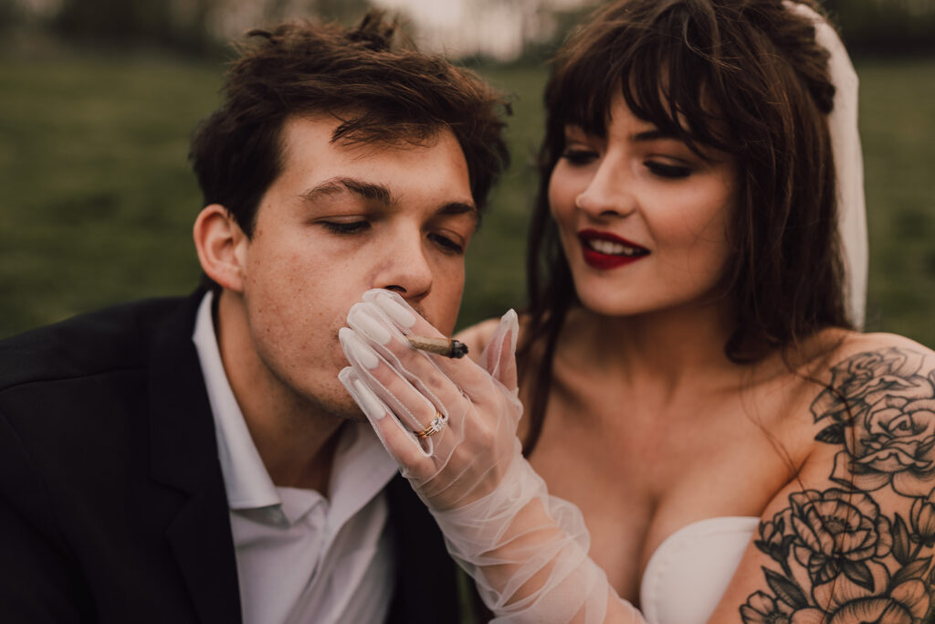 Couple kissing in Brooklyn Bridge Park smoking a joint 