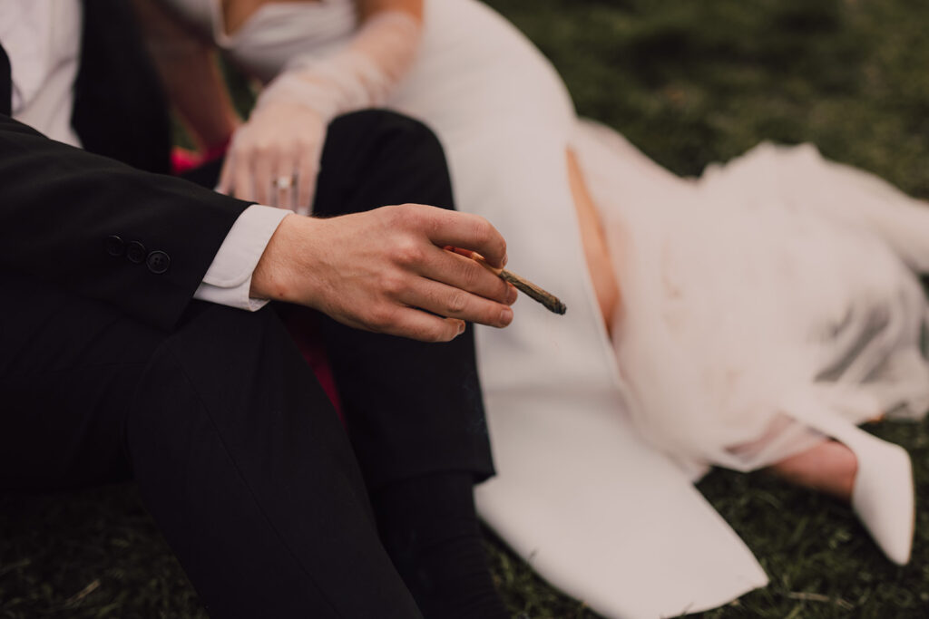 Couple kissing in Brooklyn Bridge Park smoking a joint 