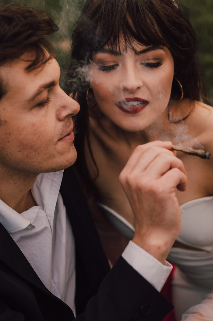 Couple kissing in Brooklyn Bridge Park smoking a joint 