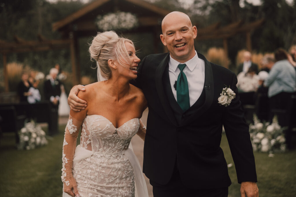 Bride and groom laughing walking up the aisle