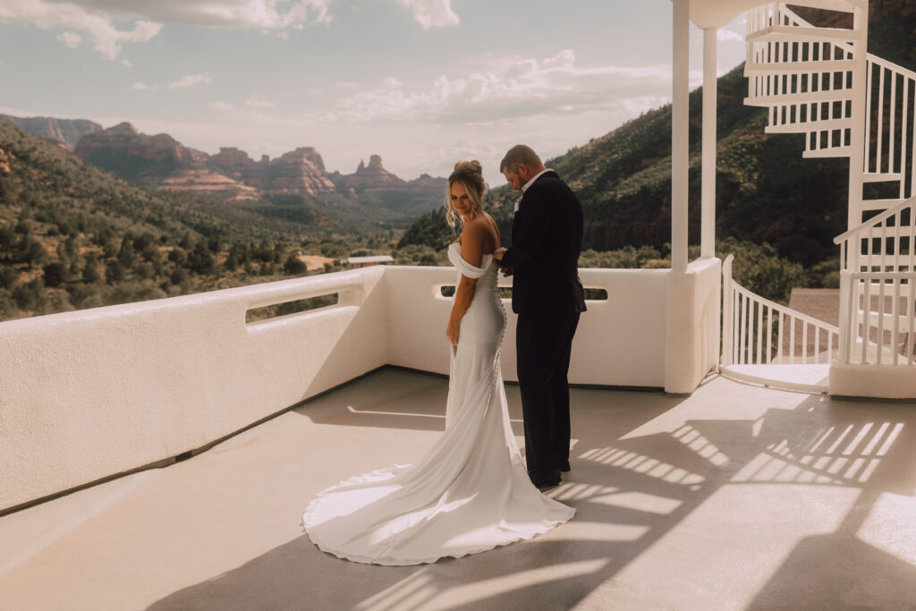 groom putting on brides dress Sedona elopement