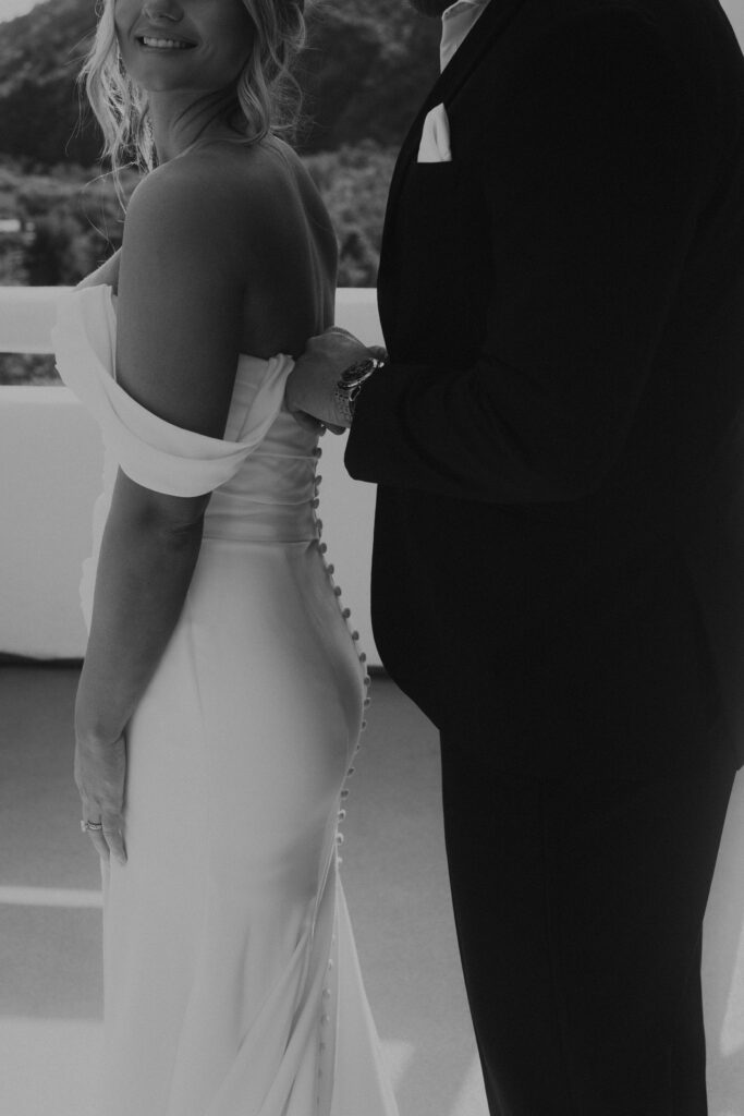 groom putting on brides dress Sedona elopement