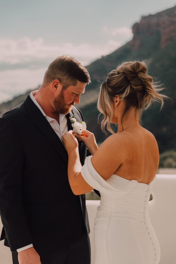 groom putting on brides dress Sedona elopement