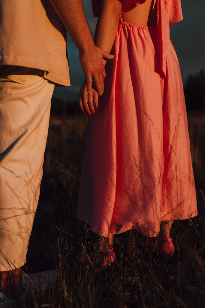 Sunset engagement session in a field with wine and props