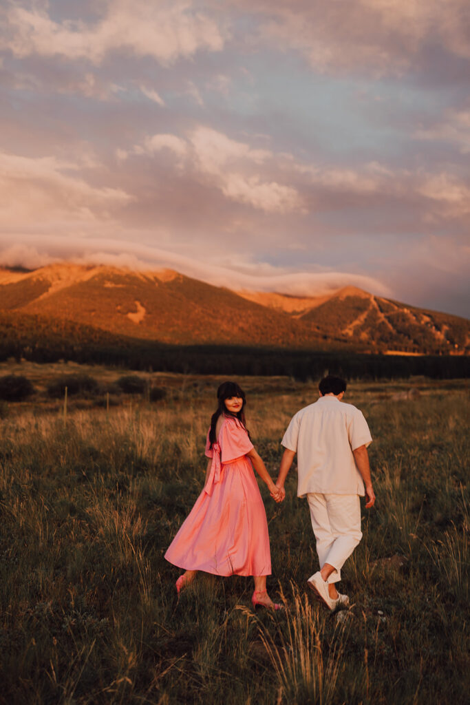 Sunset engagement session in a field with wine and props