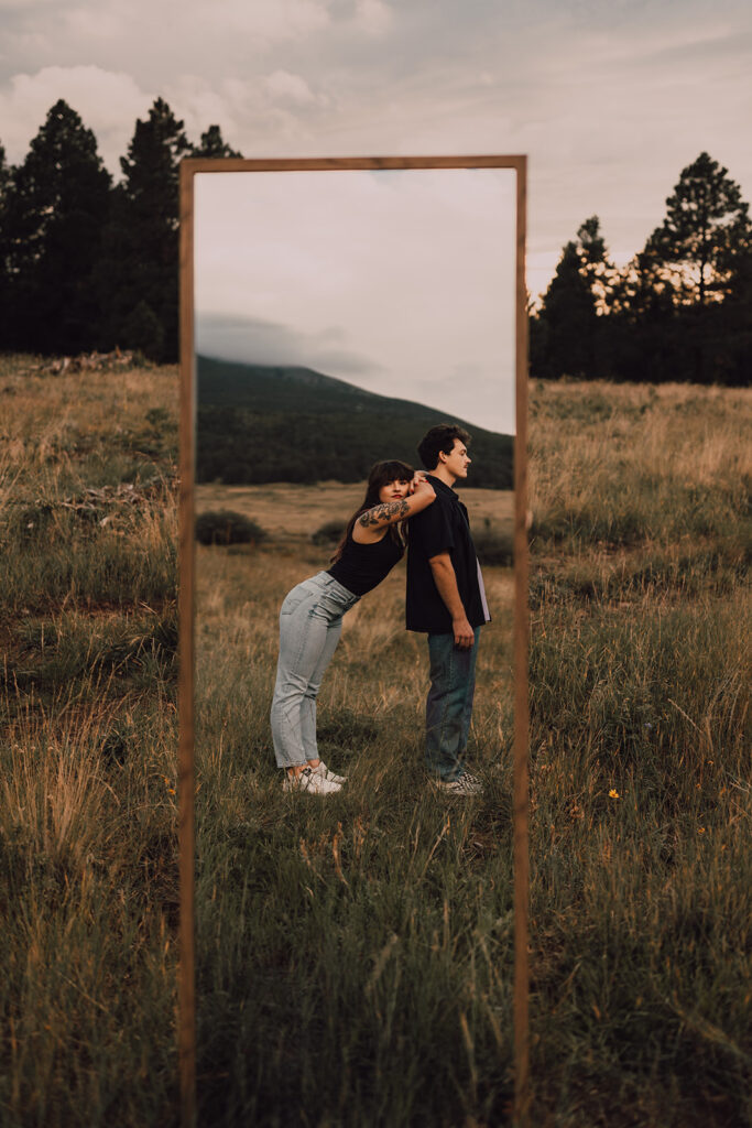 Sunset engagement session in a field with wine and props